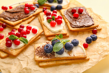 Tasty crackers with berries on table, closeup