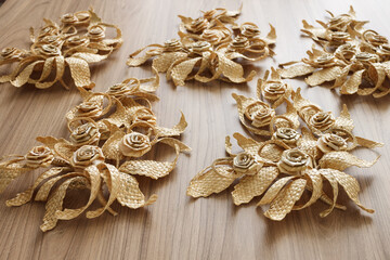 The branchs with leaves is made of straw. Straw wall decoration. The products are made of straw. Decoration of straw on a wooden  background