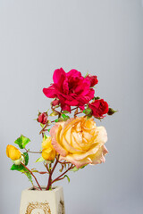 Photograph of a bouquet of natural flowers in a handmade vase on a light blue background.The photo has space to put text or whatever you want.Photo in portrait format.