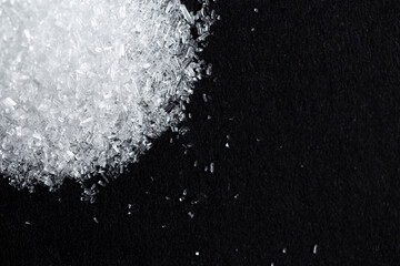 Monosodium glutamate or seasoning powder on black background and copy space. selective focus