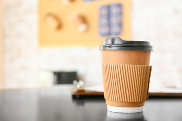 Takeaway cup for coffee on table in cafe, closeup