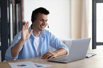 Hiring concept, smiling young man uses laptop for online video interview, successful employee of the hot line of the call center