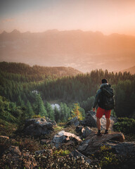 Hiker with Backpack standing on Mountain Peak - Enjoying View in the austrian alps near Schladming