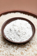 Obraz na płótnie Canvas Bowls with flour and raw rice on color background, closeup
