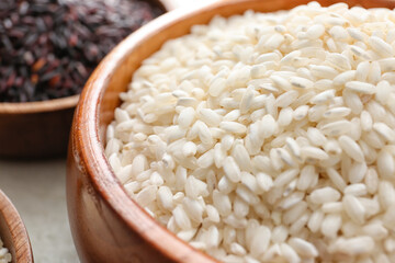 Bowl with raw rice on table, closeup