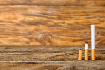 Different cigarettes on wooden background