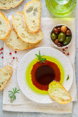 Freshly baked homemade ciabatta and a sauce of olive oil and balsamic vinegar, freshly ground pink pepper, coarse sea salt and rosemary on a light background. Mediterranean cuisine.  - 440996793