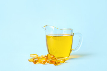 Jug of fish oil and capsules on color background