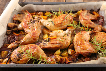 baked chicken leg with potato, garlic and herbs