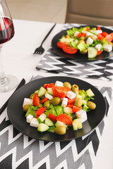 Plates with fresh Greek salad on table in restaurant