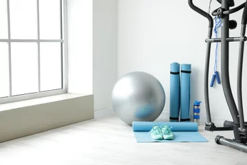 Crédence de cuisine en verre imprimé Fitness Différents équipements sportifs et ballon de fitness dans la salle de gym