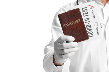 Doctor with passport and negative covid-19 test result on white background, closeup