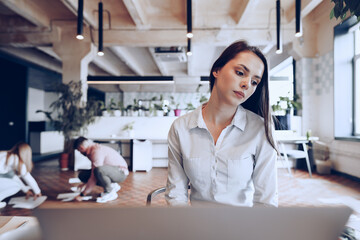Portrait of a young smart businesswoman sitting at her working table in office