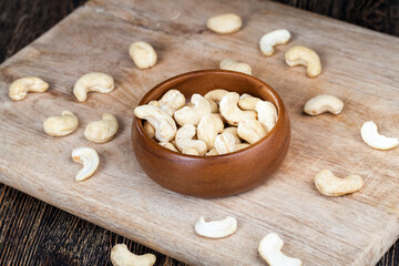 Obraz na płótnie Canvas cashew nuts on an old wooden table and in a wooden bowl