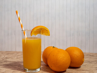 Fresh orange juice with straws in a glass.