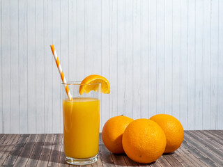 Fresh orange juice with straws in a glass.