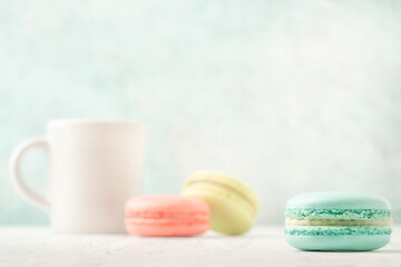 colorful macaroons and coffee on table over green with copy space