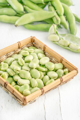 closeup fresh broad bean seeds on a wooden table