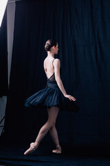 Young beautiful ballerina is posing in studio