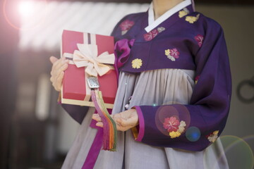 Woman in Korean traditional clothes  holding gift box