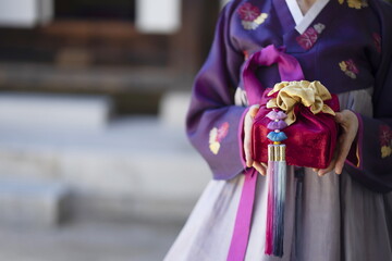 Woman in Korean traditional clothes holding traditional package