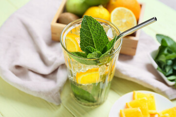 Glass of tasty ice tea with lemon on color wooden background