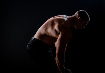 Strong bodybuilder traininig over balck background