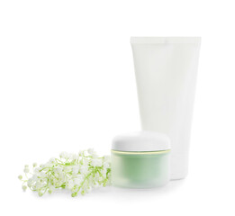 Cosmetic products and lily-of-the-valley flowers on white background