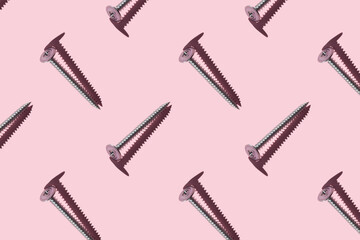 Self-tapping screws on a pink background, pattern, hard shadows. Construction tools, repairs. Background for the design.