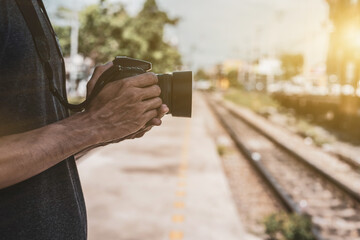 Tourists stand holding digital cameras near train tracks. concept of tourism and travel