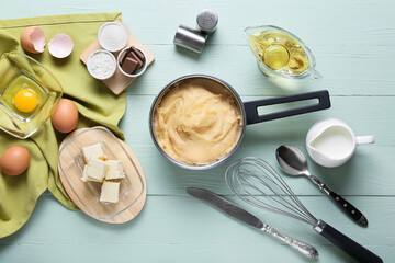 Ingredients for preparing churros on color wooden background