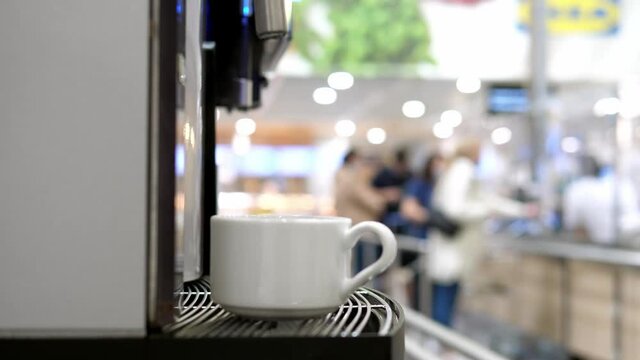 Boiling water machine, close-up hot water is poured into a tea mug, a food court.