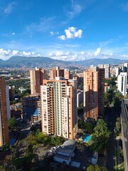 Fototapeta na wymiar Medellin, Antioquia, Colombia. December 13, 2020: landscape with mountains and blue sky. Architecture and facade of buildings in El Poblado.