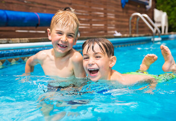 Fototapeta premium Two boy brother having fun in Pool on the summer time