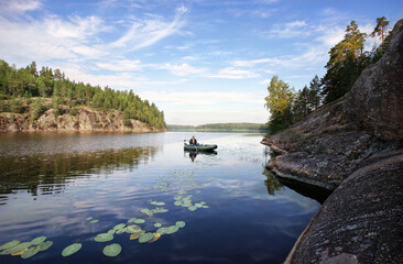 angler fishing on boat in beatiful nordic rocky bay. North Europe, Baltic sea, gulf of Finland