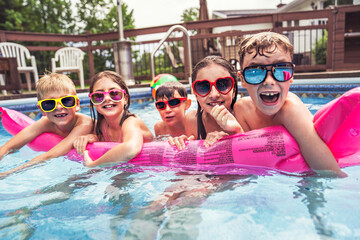 group of children having fun in Pool on the summer time