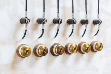 Retro style brass power switches on white wall. Brass vintage switch on interior wall.