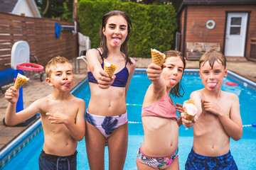 group children eating ice cream on the pool side