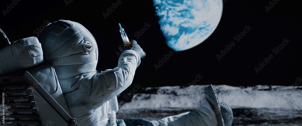 Canvas Prints back view of lunar astronaut having a beer while resting in a beach chair on moon surface, saluting 