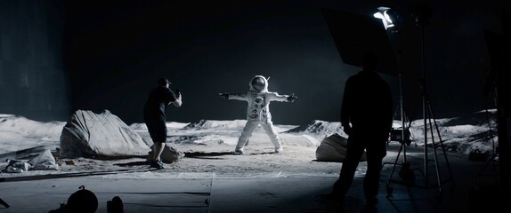 WIDE Behind the scenes, cinematographer shooting viral video for social account on a large Moon landing set. Virtual production with LED screens