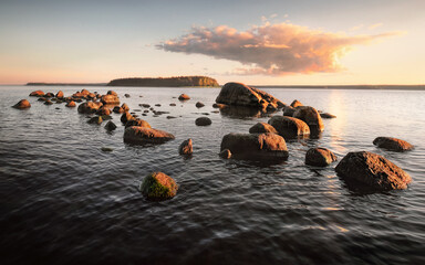 bank with boulders and stones on sunset. Shelf of Baltic sea, gulf of Finland.