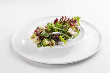 Grilled courgette with rocket salad and sesame seeds on white plate isolated on white background