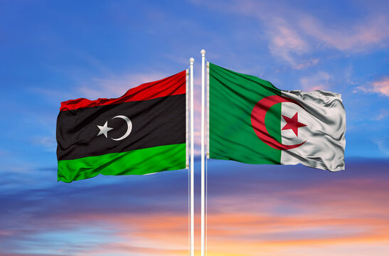 Algeria and Libya flags against of blue sky