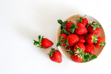 Strawberry berry with green leaf in a plate, isolated on a white background, white table. berries and food