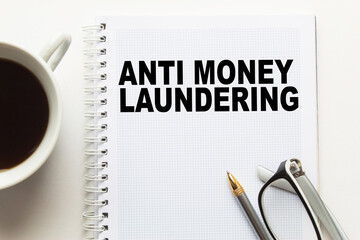 Notepad with text ANTI MONEY LAUNDERING on the office desk with stationery. A blank notepad for entering a copy or text. business
