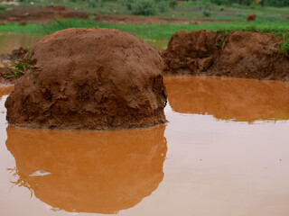 Soil mountain presented on dirty water in raining season time.
