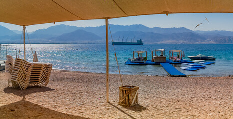 Water sport floating island and sunshade and resting facilities on sandy beach of the Red Sea,...