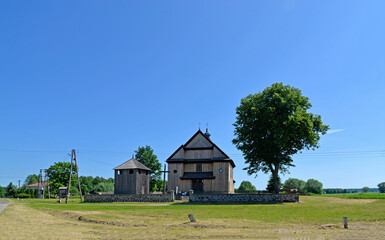 Obraz premium The belfry built in 1792 with the church of St. John the Baptist in the village of Gąsiorowo in Masovia, Poland. The photos show a general view and architectural details of the temple and belfry.