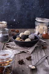 Raw energy bites balls prepared with natural ingredients on wooden background
