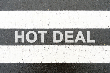 On the asphalt between the white dividing stripes the inscription - HOT DEAL